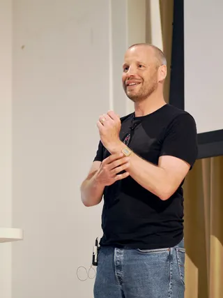 Bild von Nils Binder bei seinem Vortrag beim Pre-Event des CSS Day. Nils lächelt ins Publikum.