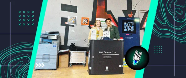 Roxy Josefus und Ares Avgerinos von 9elements stehen hinter dem Artifaction Stand bei der Millerntor Gallery 2025. Hinter ihnen sind Artifaction-Gemälde an der Wand befestigt, der Printer und der Generator sind ebenfalls zu sehen.