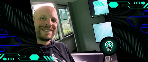 Nils Binder lächelt in die Kamera während einer Lehrveranstaltung an der FOM Hochschule; im Hintergrund sind Präsentationsfolien zum Thema Web-Technologien für den Studiengang UX Design & Digital Solutions zu sehen.