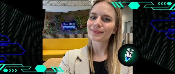 Melina Jacob beim Workshop an der Ruhr-Universität Bochum im Makerspace. Im Hintergrund sichtbar: ein gelbes Sofa und das RUB Makerspace-Logo vor einer begrünten Wand.